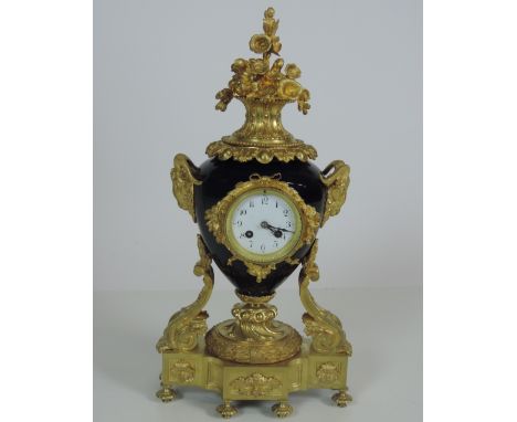 A large French style ormolu and porcelain Mantle Clock, the vase shaped royal blue porcelain body with elaborate floral crest