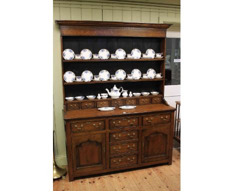 Oak dresser, the shelf back having seven spice drawers above a base of six drawers and two arched panel doors