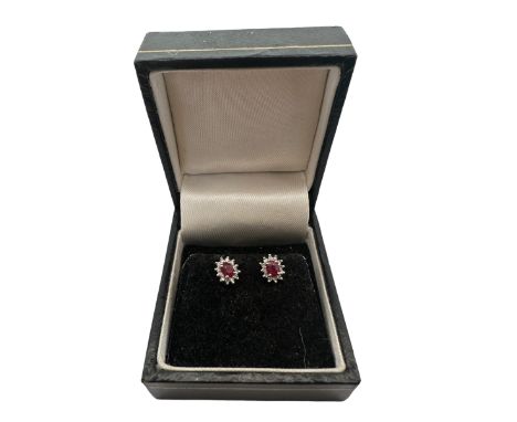 A pair of ruby and diamond cluster earrings. Set in hallmarked 9ct white and yellow gold. Please see the buyer's terms and co