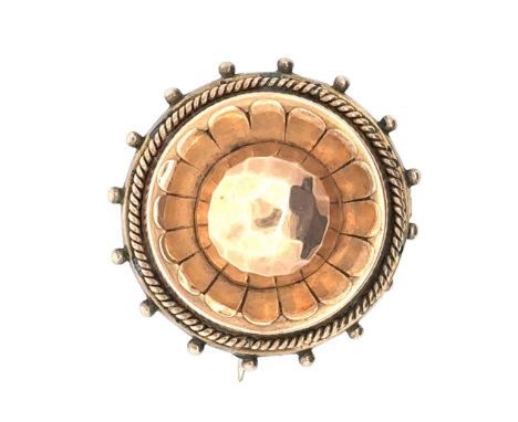 A Victorian yellow metal circular brooch with faceted central dome and glass panel to the reverse containing hair. Diameter a