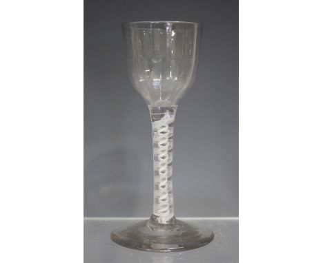 A double series opaque twist wine glass, mid-18th century, with basal fluted ogee bowl, the stem with eleven-ply spiral band 