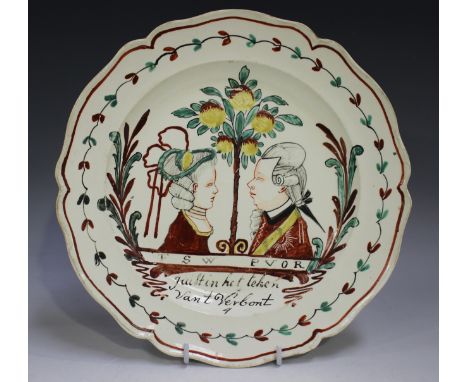 A Dutch decorated English creamware plate, circa 1770, painted with opposing bust profile portraits of Prince William V of Or