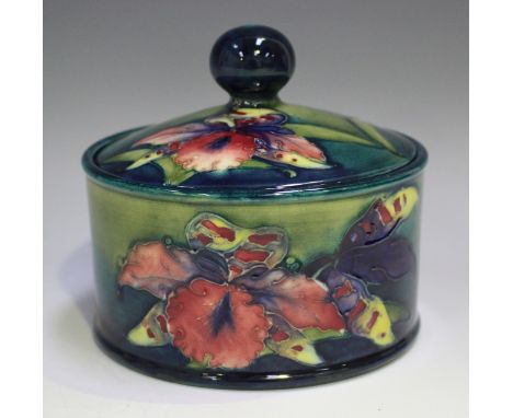 A Moorcroft Orchid pattern circular pot and cover, 1928-49, impressed marks and painted initials to base, height 12cm, diamet