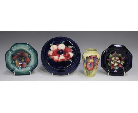 Four pieces of Moorcroft pottery, comprising an Orchid pattern miniature vase, height 9.2cm, an Anemone circular teapot stand