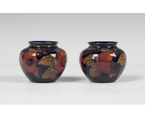 A small pair of Moorcroft Pomegranate pattern vases, circa 1928-25, impressed marks to bases, height 6.5cm.Buyer’s Premium 29