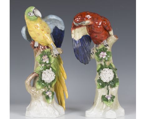 A pair of Sitzendorf Meissen style models of parrots, early 20th century, the polychrome birds perched on floral encrusted tr