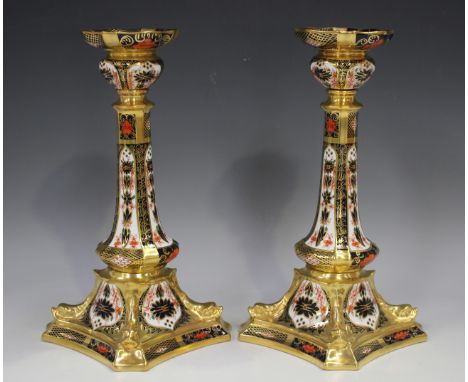 A pair of Royal Crown Derby Imari pattern candlesticks of tapering baluster form, on square canted corner and moulded dolphin