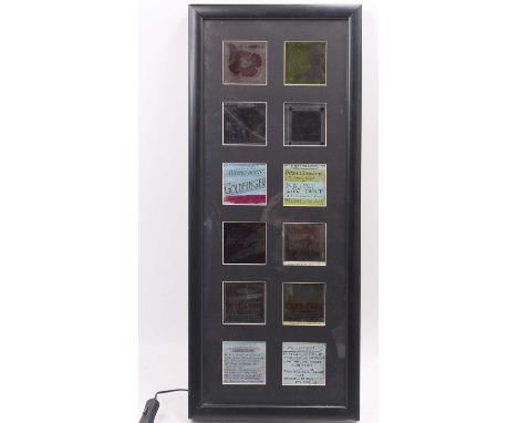 A framed &amp; glazed collection of 12 cinema film projector slides, all dating from the 1960s, fully framed in an electrical
