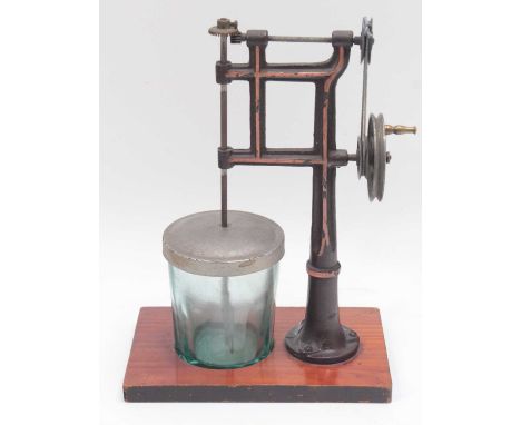 A Marklin cast iron and hand operated model of a butter churn, measuring 21cm high, 15x9cm wooden base, handpainted in brown 