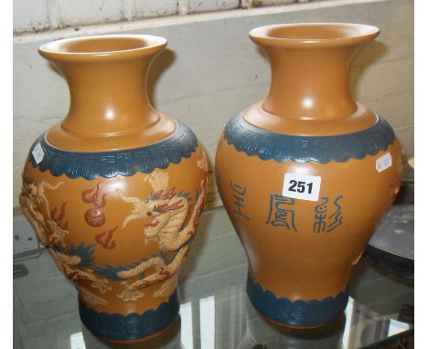 Pair of Chinese Yixing earthenware vases decorated with relief modelled dragons and birds impressed seal mark to bases