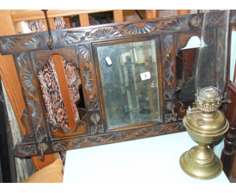 Carved oak hall mirror with coat hooks, and brass oil lamp