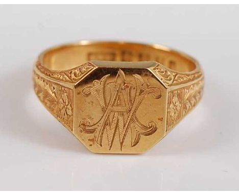 An 18ct yellow gold octagonal signet ring, with interlinking initials AW and shoulders engraved with floral design, head dime