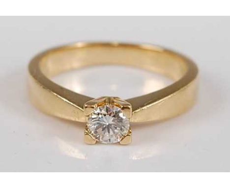 A yellow metal diamond single stone ring, featuring a round brilliant cut diamond in a four-claw V-shaped setting, diamond di