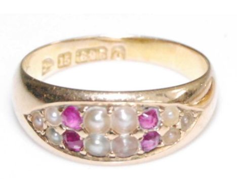 A late Victorian 15ct gold dress ring, having four rubies and ten approx 1.6 to 2.3mm seed pearls grain set in a boat shaped 