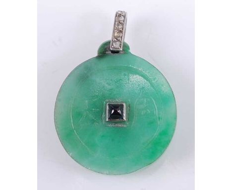 An Art Deco jade disc pendant, incised to either side with simplistic Chinese symbols and centre set with a cabochon blue sap