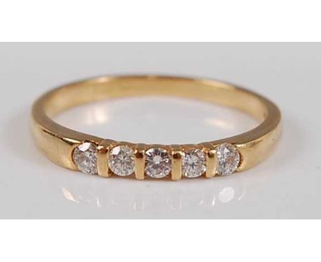 An 18ct yellow gold diamond five stone half hoop eternity ring, comprising five round brilliant cut diamonds in bar settings,