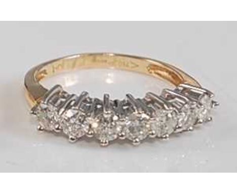 An 18ct yellow and white gold diamond seven-stone half hoop eternity ring, featuring seven round brilliant cut diamonds in cl