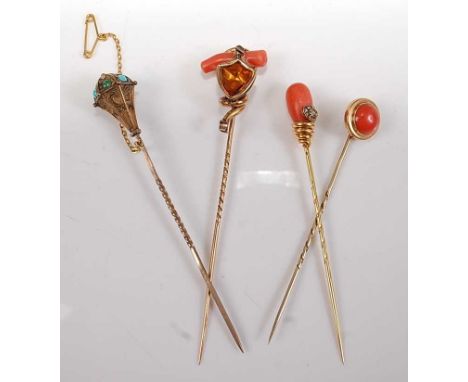 A collection of four late 19th century stick pins, comprising: a yellow metal shield shaped stick pin set with a citrine and 