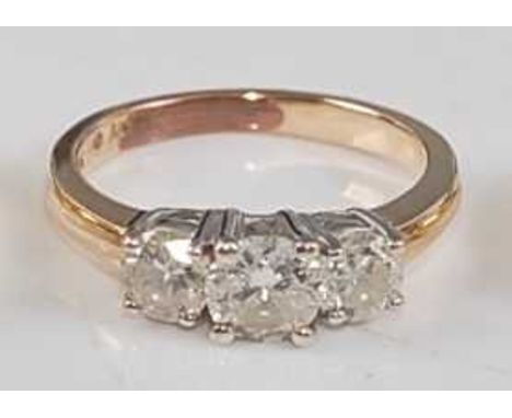 A yellow metal diamond three-stone ring, having three graduated round brilliant cut diamonds, all in claw settings, diamond d