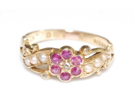 An 18ct yellow gold Edwardian flower cluster ring, comprising a centre section of six round faceted rubies around a rose cut 