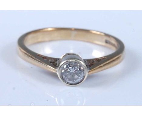 A 9ct yellow and white gold diamond solitaire ring, having a round brilliant cut diamond in a bezel setting, diamond dimensio