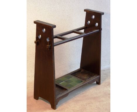 An early 20th Century Arts and Crafts oak Stick Stand in Liberty & Co., style, the tapering vertical supports each pierced wi