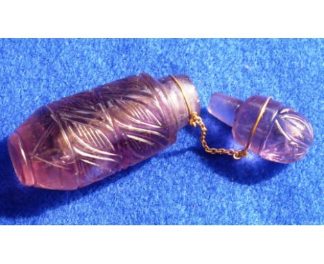 A small amethyst quartz Scent Bottle and Stopper, the Stopper attached to the body with chain, hand cut decoration of angular