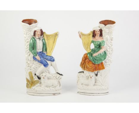 PAIR OF NINETEENTH CENTURY STAFFORDSHIRE FLAT BACK SPILL VASE FIGURES, each heightened in colours and modelled as a seated mu