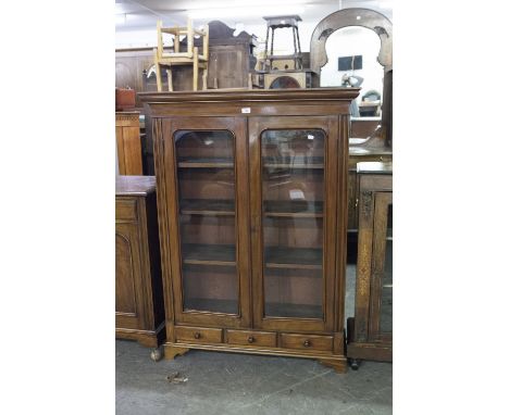 MAHOGANY BOOKCASE, HAVING TWO GLAZED DOORS AND THREE DRAWERS BELOW ON BRACKET FEET 