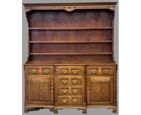 LATE 19th CENTURY CROSSBANDED OAK NORTH WALES DRESSER with breakfront, three shelf rack and a T-arrangement of opening drawer