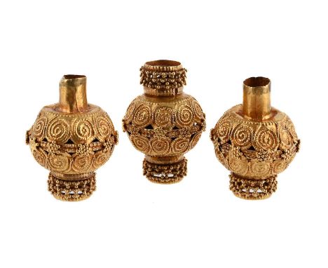
	
		THREE DECORATIVE BEADS 
		The hollow gold coloured beads with scrolled and beaded decoration, unmarked  
		Size/dimensio