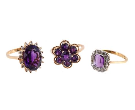 
	
		THREE AMETHYST CLUSTER DRESS RINGS 
		The first with a step cut amethyst with canted corners, within a surround of rose 