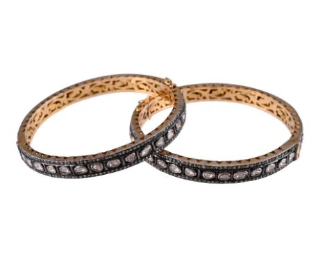 
	
		A PAIR OF POLKI DIAMOND SET HINGED BANGLES 
		The polki diamonds between two rows of eight cut diamonds, unmarked
		Size