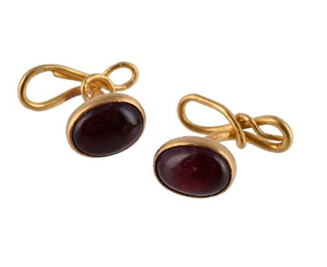 
	
		A PAIR OF RUBY CUFFLINKS 
		The cabochon rubies within collet settings to curving whiplash knotted backs, unmarked
		Siz