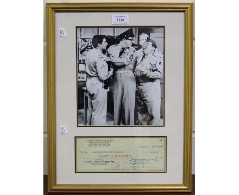 AUTOGRAPHS. A cheque signed by Phil Silvers, mounted below a black and white photograph, within a gilt frame, overall 44cm x 