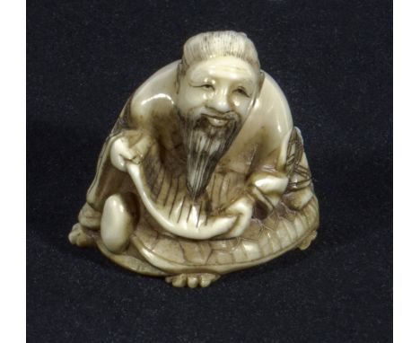 A Japanese ivory netsuke man reading a scroll, signed