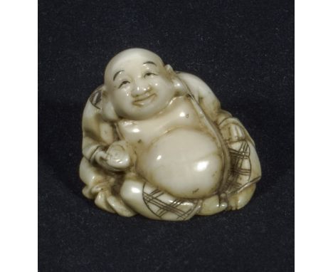 A Japanese ivory netsuke, of a seated Buddha, signed