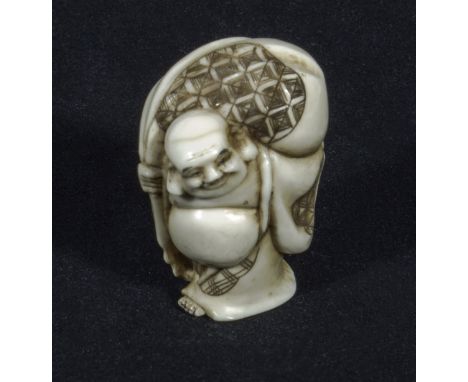 A Japanese ivory netsuke, Hotei carrying a large sack, signed