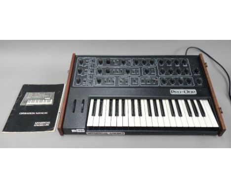 A sequential circuits 'Pro-One' synthesizer, circa 1983, J-wire, with later hardwood lid and operation manual, 65.5cm wide.