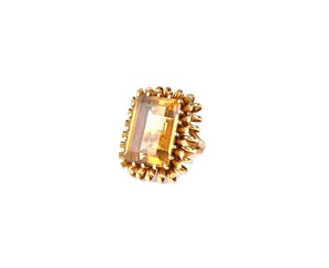 A gold and citrine single stone ring, claw set with a large rectangular step cut citrine, within a looped wirework surround, 