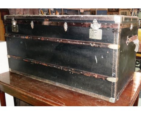 An early 20th century steamer trunk 120cm wide x 61cm high and a leather bound lift top trunk, 83cm wide x 53cm high (2).
