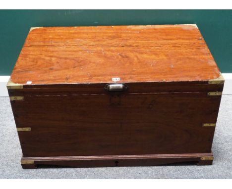 A 19th century brass bound rectangular teak trunk, with side carry handles, on a plinth base, 94cm wide x 48cm high x 63cm de