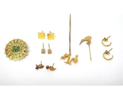A 9ct gold and green enamelled shaped circular brooch, mounted with a small circular cut diamond above a cypher motif, gross 