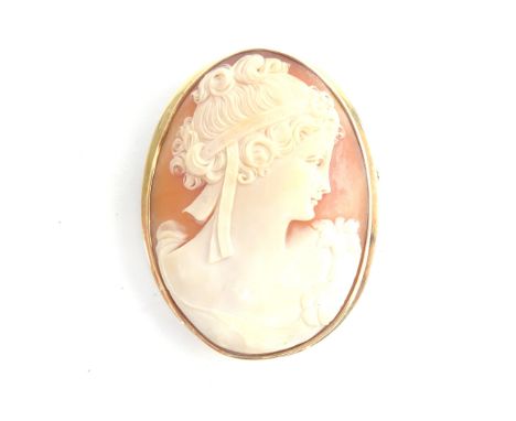 A gold mounted oval shell cameo brooch, carved as the portrait of a lady, her hair tied with a ribbon, detailed 585.