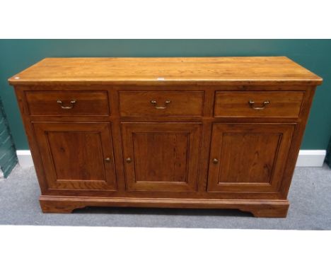 Willis & Gambier; an oak dresser base, with three drawers over cupboards, on bracket feet, 156cm wide x 89cm high x 50cm deep