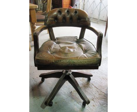 A 20th century mahogany framed button back leather upholstered office swivel open armchair.