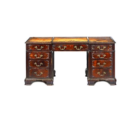 A mid-18th century style carved mahogany pedestal desk, the inverted breakfront top over nine drawers about the knee, on ogee