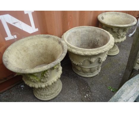 A pair of 20th century reconstituted stone garden urns, relief cast with swag and sash decoration and a similar planter, (3).