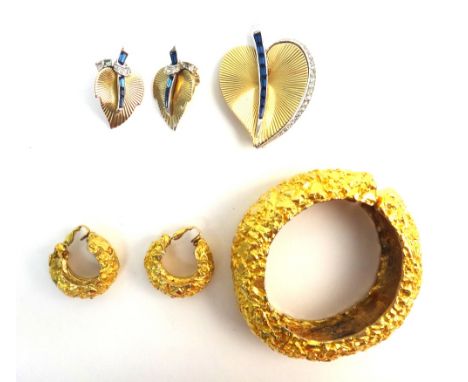 A Boucher gilt metal, blue and colourless paste set brooch and a similar pair of earclips, designed as stylized leaves, a Ken