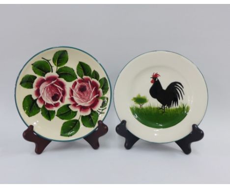 Two Griselda Hill Wemyss Ware pottery plates to include one with a Cockerel and the other with cabbage roses, 17cm (2)